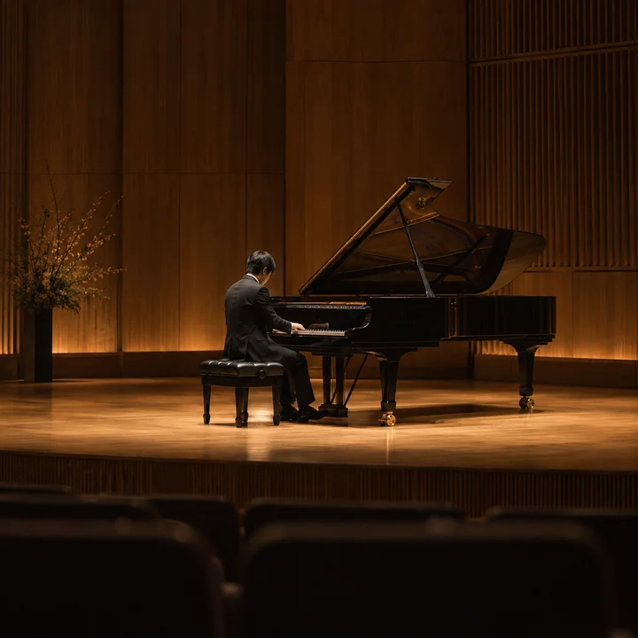 Ein Pianist gibt einen Klavierabend in einem ruhigen kleinen Saal